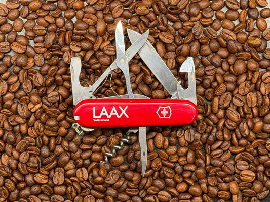 Swiss Army knife with red handle on coffee beans