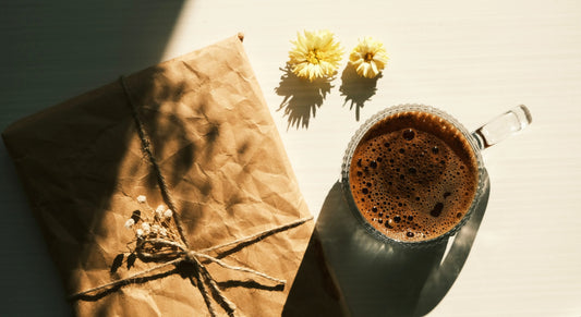 Inslaget paket bredvid en kopp svart kaffe.