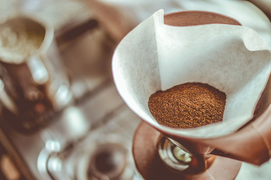 Malet kaffe i ett pappersfilter i en pour-over dripper.