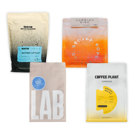 Fyra kaffepåsar från olika märken na vit bakgrund