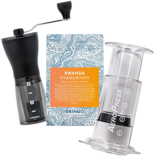 Hario Mini Mill kaffekvarn, Gringo Rwanda kaffepåse och AeroPress Clear på en vit bakgrund.