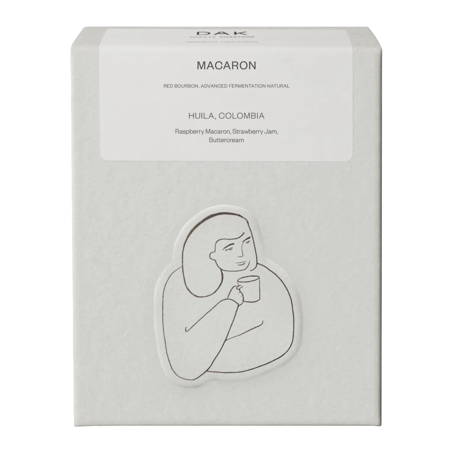Vit kartong från DAK Coffee Roasters "Colombia Macaron" filterkaffe hela bönor med en svartvit illustration av en person