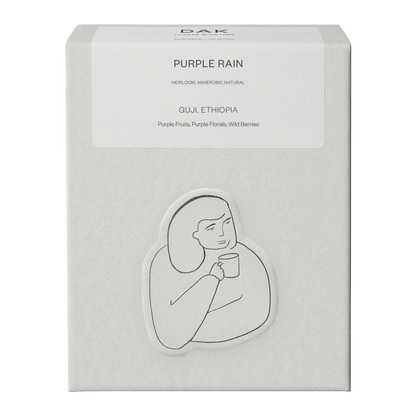 Vit ask DAK Coffee Roasters Purple Rain Filter hela bönor med svartvit teckning av en person