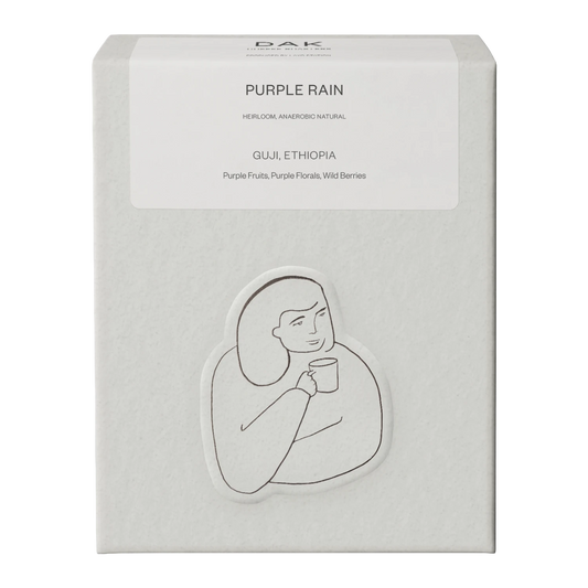 White box of DAK Coffee Roasters Purple Rain Filter Whole Beans with black on white drawing of a person