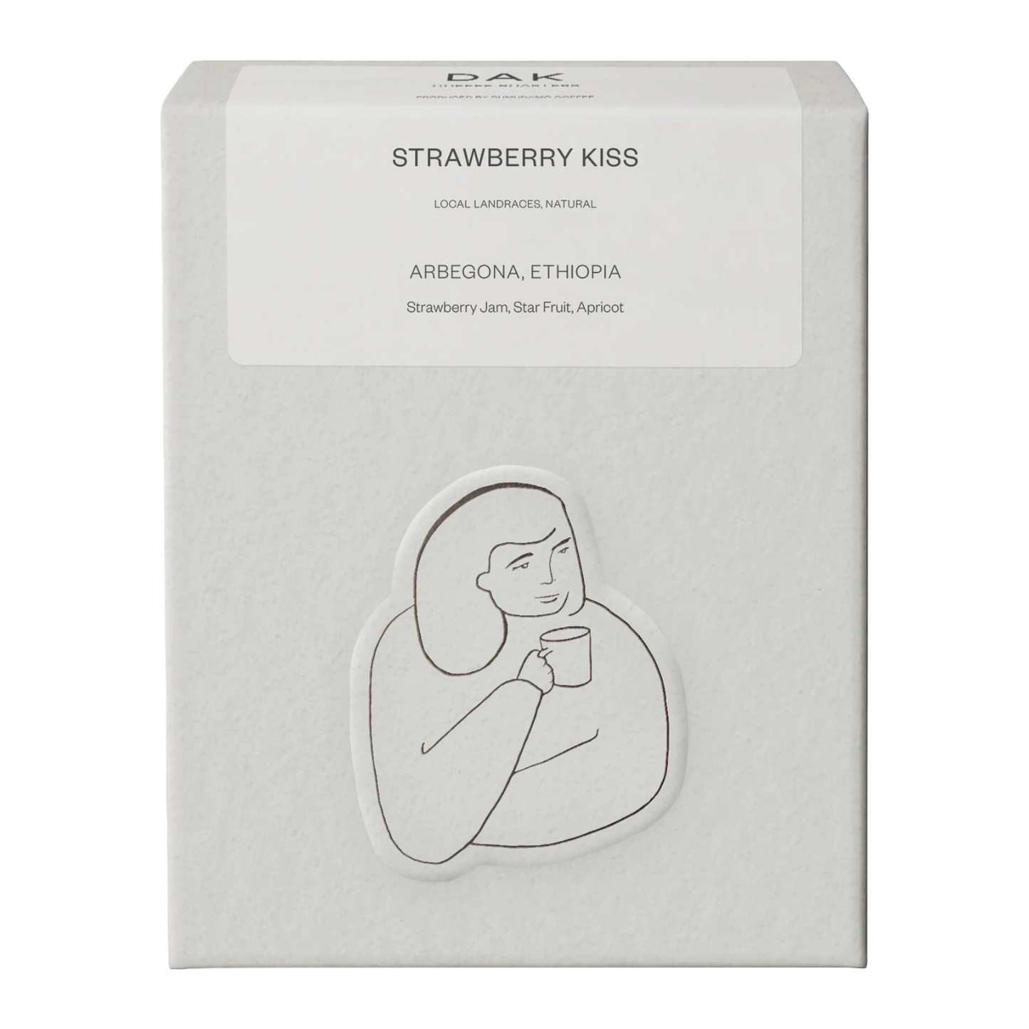 Vit låda DAK Coffee Roasters Ethiopia ”Strawberry Kiss” med svartvit teckning av en person.