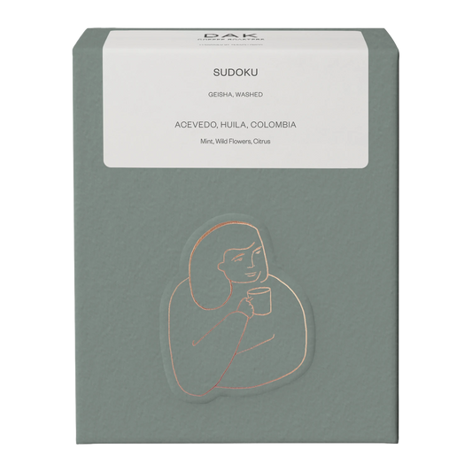 Green box of DAK Coffee Roasters Colombia Sudoku Filter Whole Beans with gold on green drawing of a person