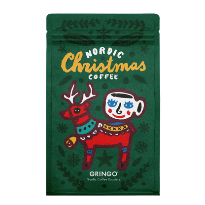 A green Gringo Nordic Christmas Coffee bag featuring a festive illustration of a red reindeer and a white mug with blue eyes, on a white background.