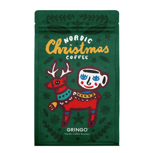 A green Gringo Nordic Christmas Coffee bag featuring a festive illustration of a red reindeer and a white mug with blue eyes, on a white background.