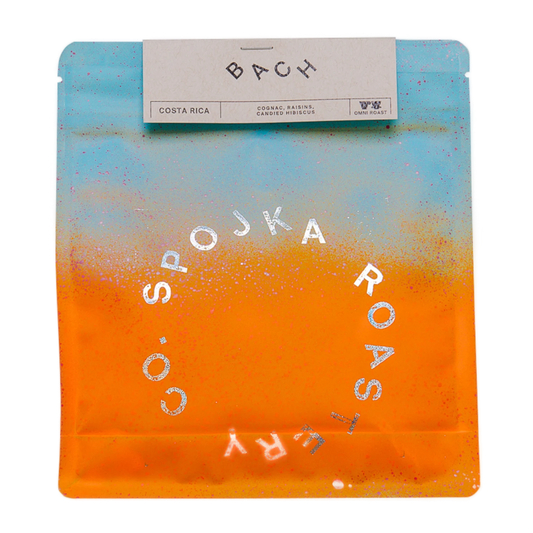 Spojka Roastery kaffeförpackning med gradientfärg och texten "BACH" på vit bakgrund.