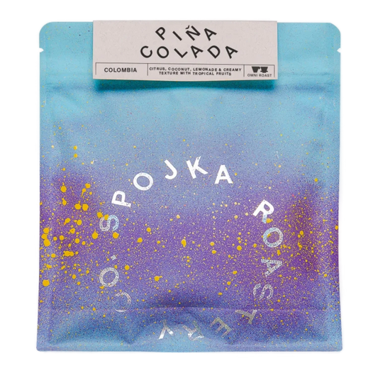 Spojka Roastery PINA COLADA Colombia coffee bag with blue to purple gradient and yellow splatter