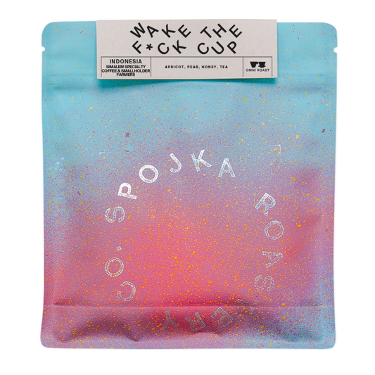 Packaged coffee with 'WAKE THE F*CK CUP' and 'SPOJKA ROASTERY' branding on a gradient background