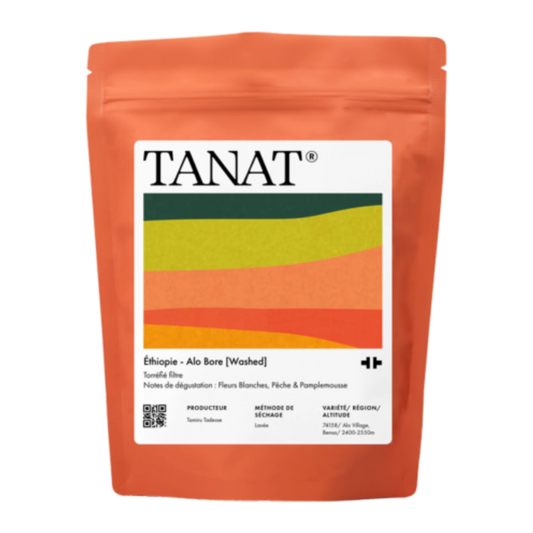 En ståpåse med TANAT Etiopien - Alo Bore (Washed), med en ljus orangeröd påse med en stor vit etikett som innehåller en färgglad våggrafik.