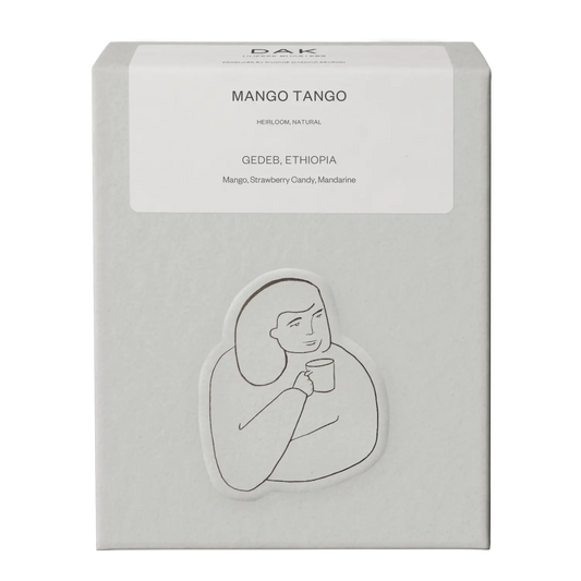 White box of DAK Coffee Roasters Mango Tango Filter Whole Beans with black on white drawing of a person