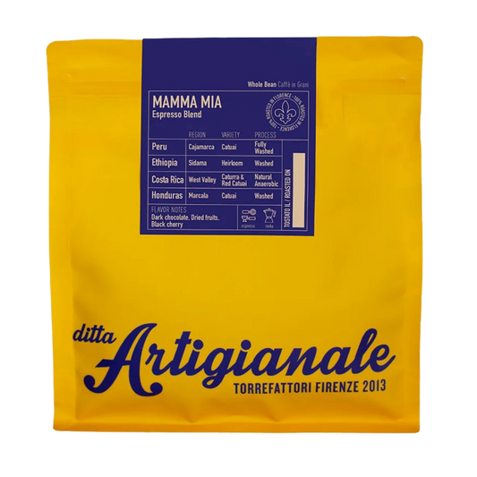 A yellow coffee bag with a dark blue label reading 'MAMMA MIA Espresso Blend' and large 'ditta Artigianale' branding on the front, photographed on a plain white background.