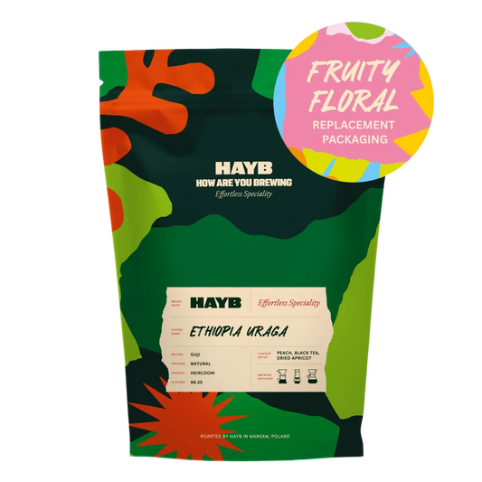 A stand-up pouch of HAYB Ethiope Uruga coffee with a colorful camouflage pattern in green, orange, and black. A pink circular badge in the top right reads 'FRUITY FLORAL REPLACEMENT PACKAGING'.