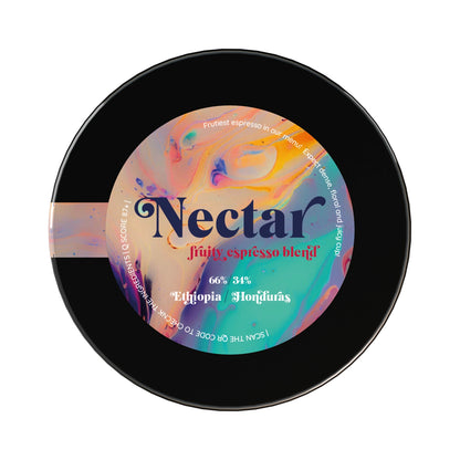 En svart rund kaffebehållare med en färgglad etikett "Nectar fruity espresso blend".