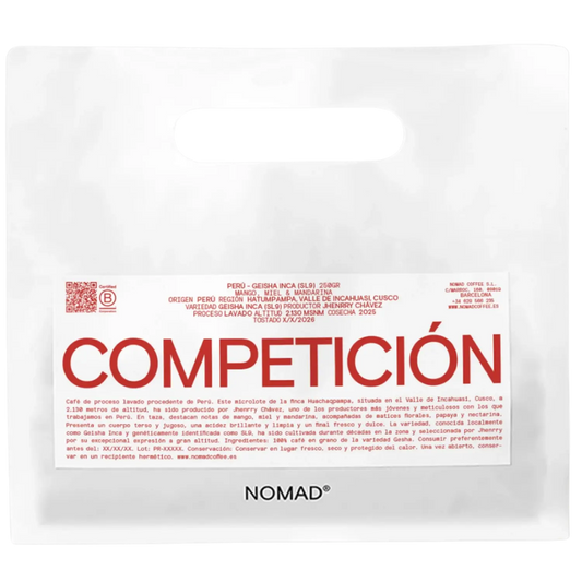 A white bag of NOMAD brand coffee with a prominent white label featuring the brand name 'COMPETICION'.
