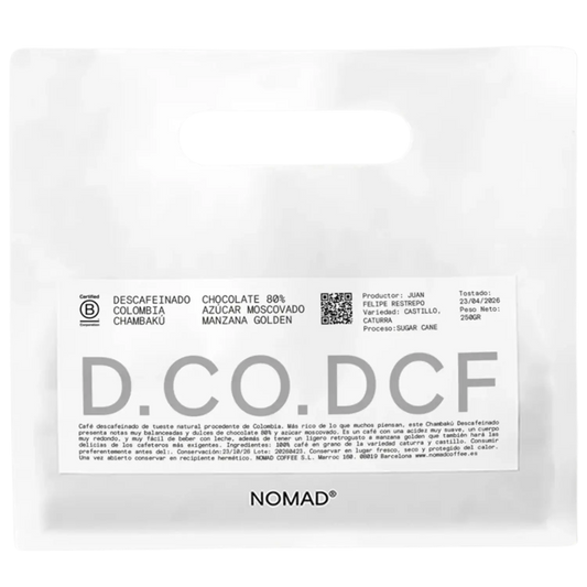 A white stand-up pouch of NOMAD Chocolate 80% Descafeinado Colombia Chambaku, featuring a white label with black and gray text and a QR code.