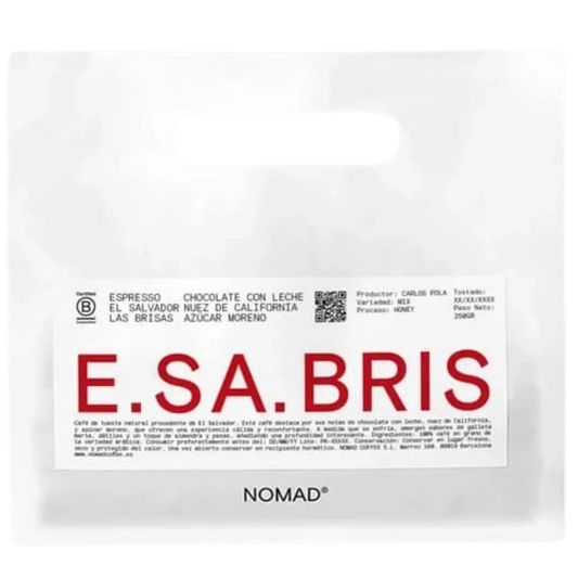 A white bag of NOMAD brand coffee with a prominent white label featuring the brand name 'E.SA.BRIS.