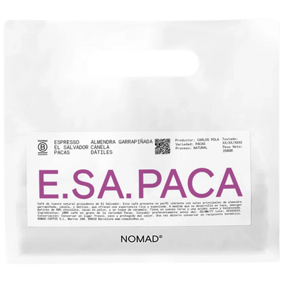 A white bag of NOMAD brand coffee with a prominent white label featuring the brand name 'E.SA.PACA'.