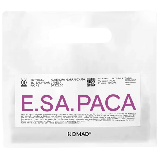 A white bag of NOMAD brand coffee with a prominent white label featuring the brand name 'E.SA.PACA'.