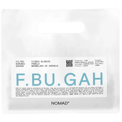 A white bag of NOMAD brand coffee with a prominent white label featuring the brand name 'F.BU.GAH'.