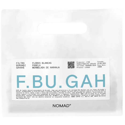 A white bag of NOMAD brand coffee with a prominent white label featuring the brand name 'F.BU.GAH'.