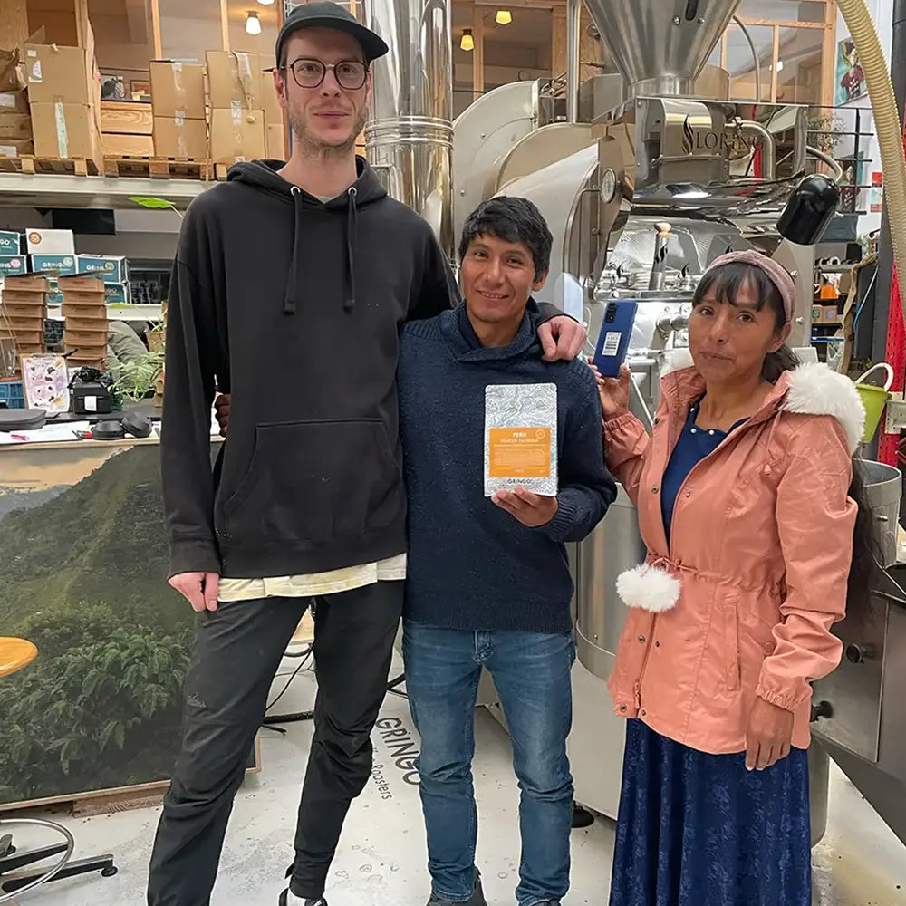 Gringo Nordic-rostare och peruanska bönder som håller en påse Nueva Florida-kaffe inne i rosteriet