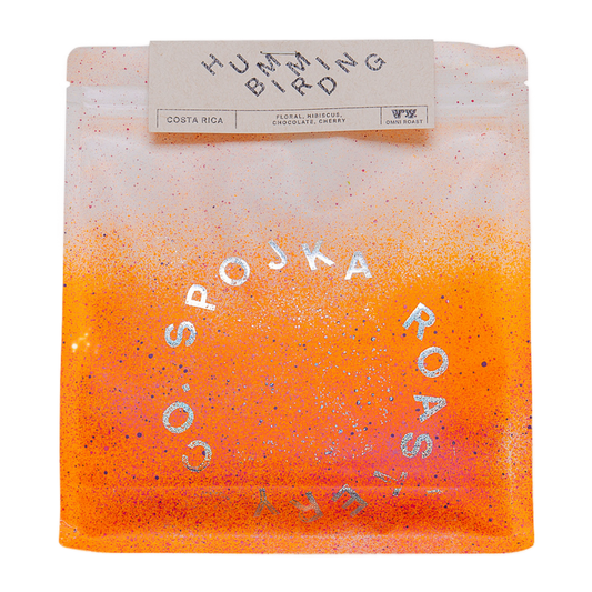 Spojka Roastery Hummingbird Costa Rica Omni Roast kaffepåse med orange gradient, rosa prickar och silvertext