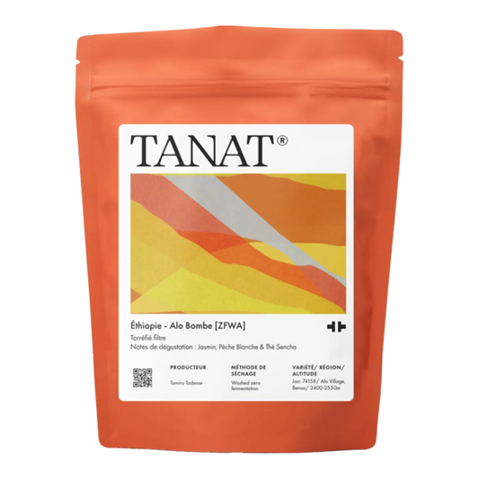 A stand-up pouch of TANAT Ethiopia - Alo Bombe [ZFWA] whole bean coffee in terracotta orange packaging with a white label featuring diagonal stripes.