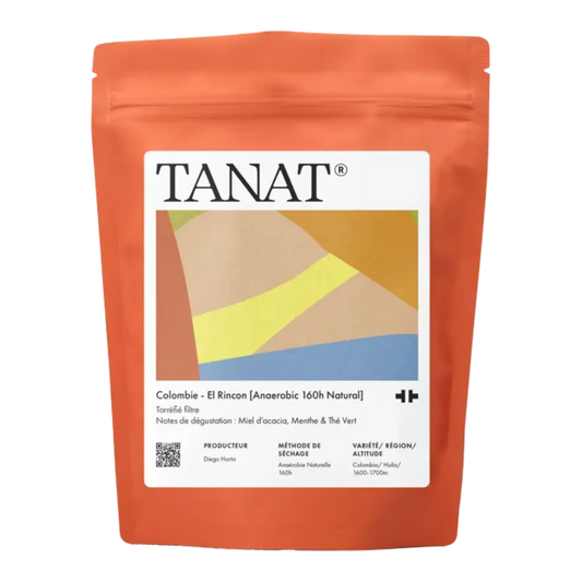 A stand-up pouch of TANAT Colombie El Rincon whole bean coffee in terracotta orange packaging with a white label featuring diagonal stripes.